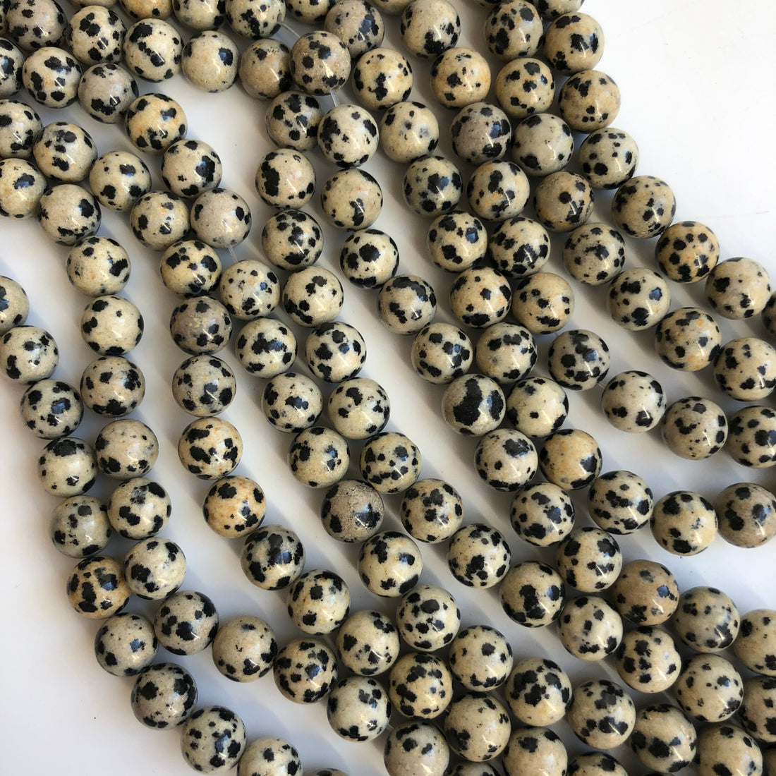 image of round dalmatian jasper gemstone on a strand