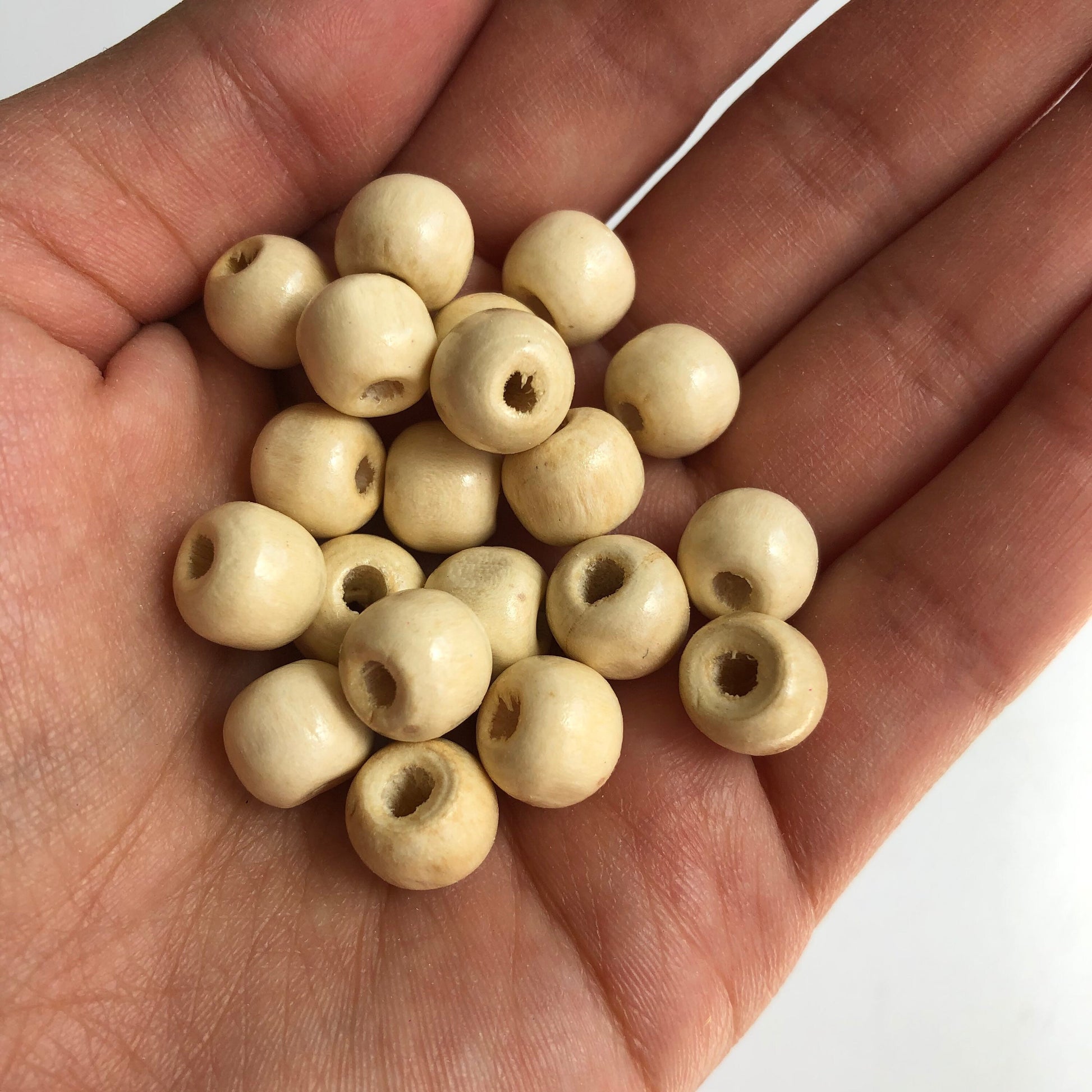 Round Beige Wood Beads in hand