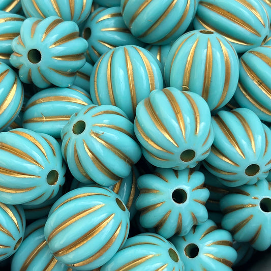 Close-up of aqua blue pumpkin bead with metallic gold stripes